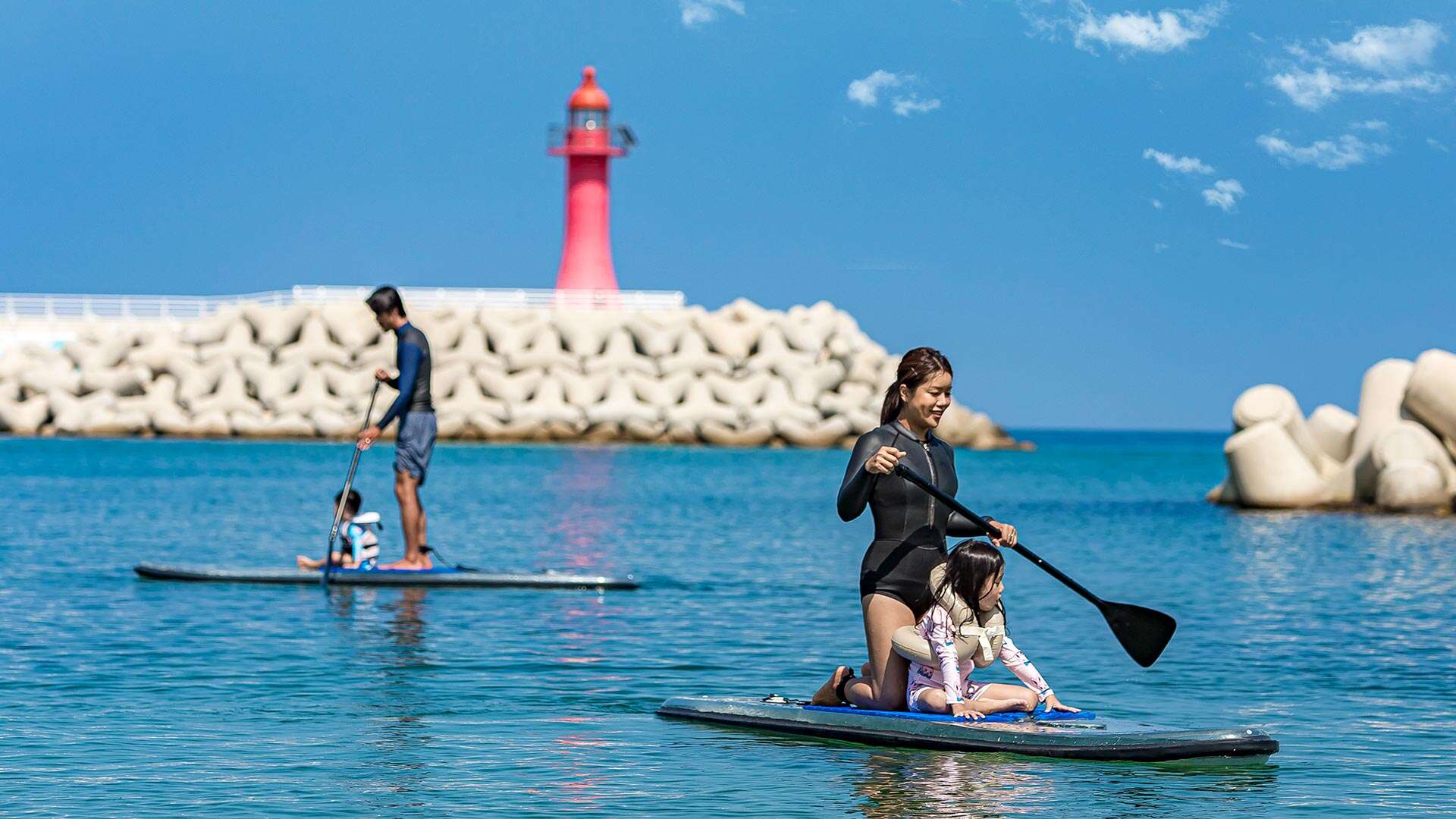 People enjoying paddleboarding with their children 02